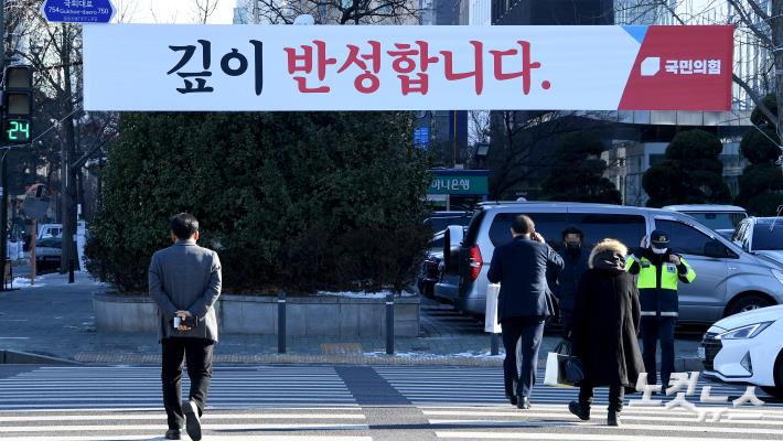 4일 오후 서울 여의도 국회 앞 횡단보도에 "깊이 반성합니다"라고 적힌 국민의힘 플래카드가 걸려 있다.