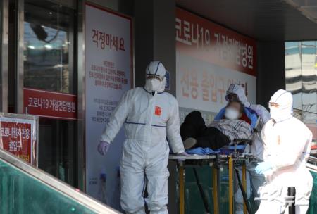 코로나19 확진자 이송하는 의료진