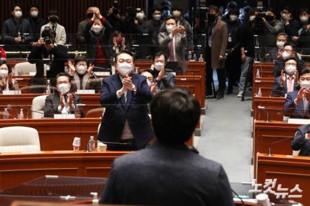국민의힘 윤석열 대선 후보가 6일 국회에서 열린 의원총회에서 이준석 대표의 발언에 일어나 박수를 치고 있다.