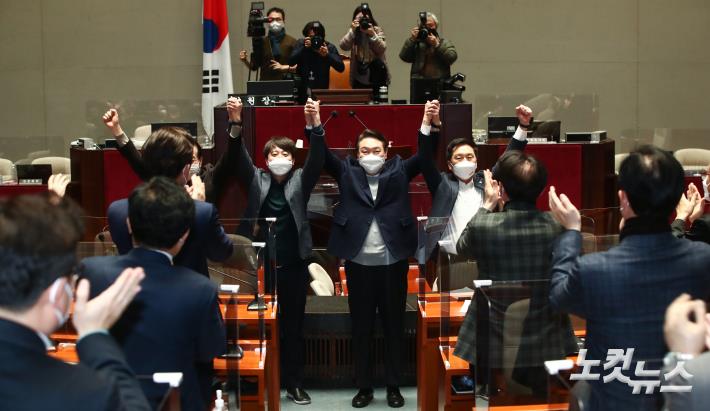 국민의힘 이준석 대표와 윤석열 대선 후보가 6일 국회에서 열린 의원총회에서 의원들을 향해 손을 들어보이고 있다.