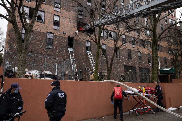 9일(현지시간) 화재가 발생한 미국 뉴욕시 브롱크스의 한 아파트에서 소방관과 경찰이 배치된 모습. 연합뉴스
