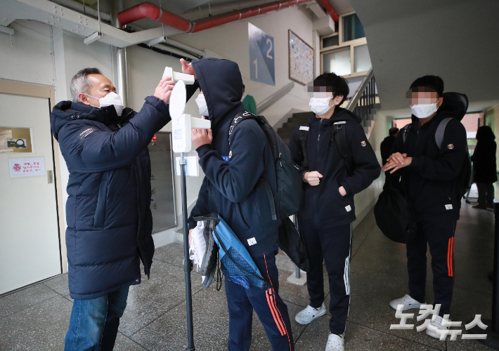 지난해 11월 서울 강서구 염창중학교에서 학생들이 등교를 하며 체온을 측정하고 있다. 사진공동취재단