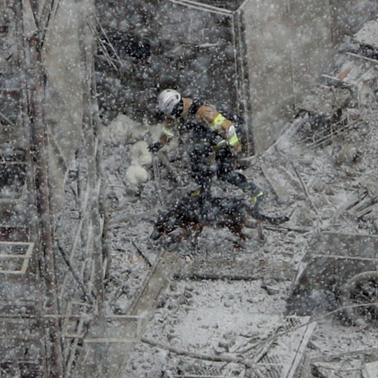 광주 아파트 붕괴 사고 사흘째를 맞은 13일 구조대원들과 수색견이 악천후 속 실종자 수색 작업을 벌이고 있다. 연합뉴스