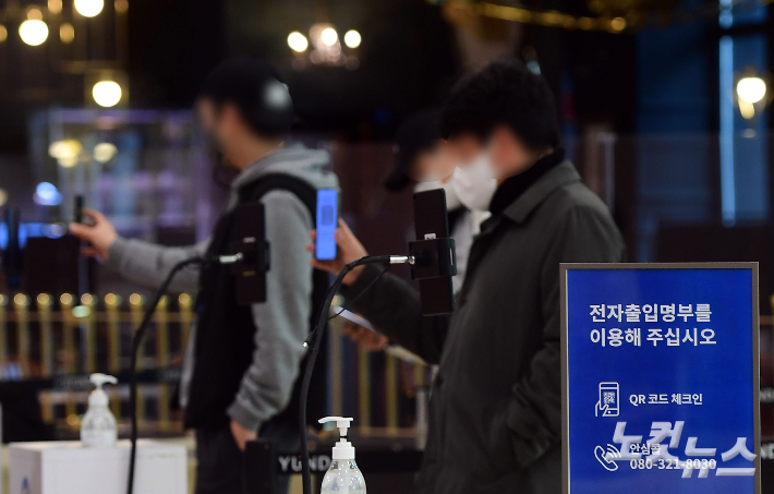 서울시내 한 백화점 입구에서 시민들이 전자출입명부 QR코드를 찍고 있다. 황진환 기자