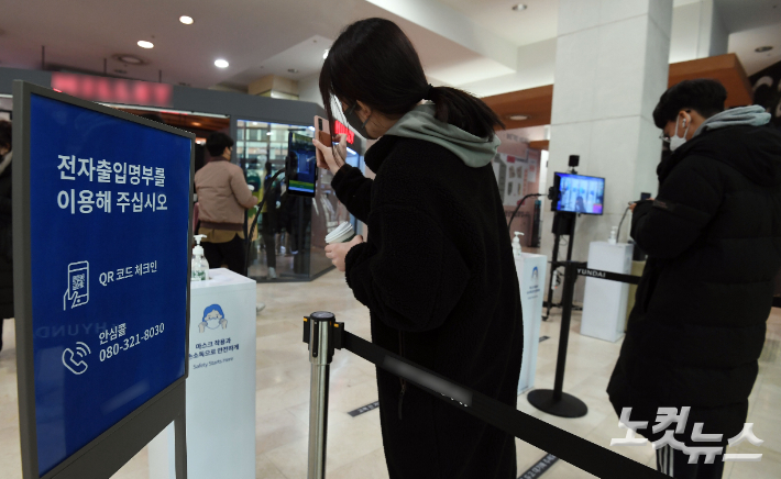 서울 시내 한 백화점 입구에서 시민들이 전자출입명부 QR코드를 찍고 있다. 황진환 기자