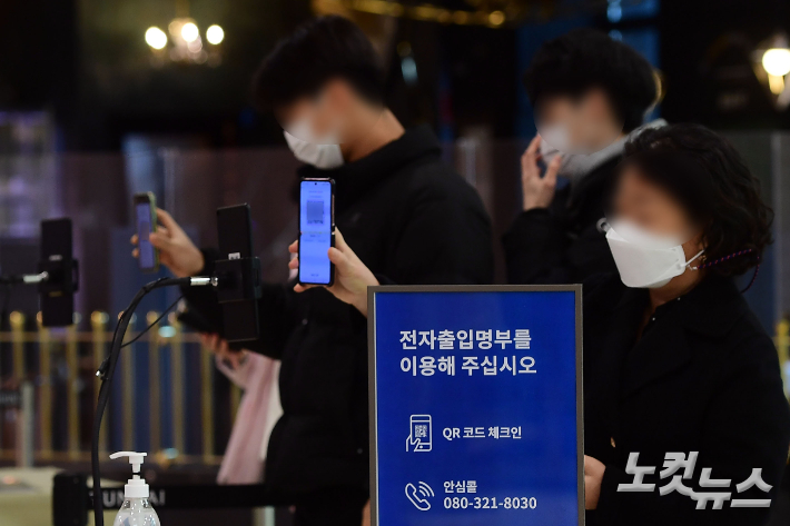 서울 시내 한 백화점 입구에서 시민들이 전자출입명부 QR코드를 찍고 있다. 황진환 기자