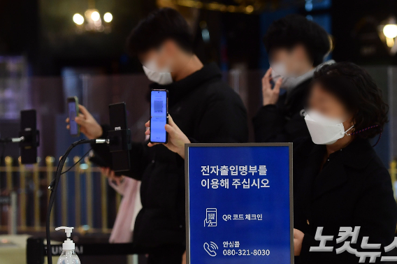 서울 시내 한 백화점 입구에서 시민들이 전자출입명부 QR코드를 찍고 있다. 황진환 기자
