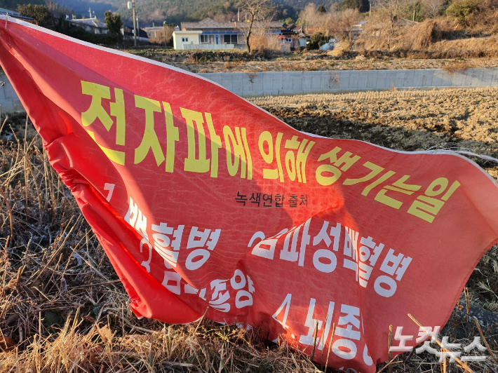 전자파에 의해 생기는 일이라는 붉은 색 현수막이 마을에 걸렸다. 고영호 기자