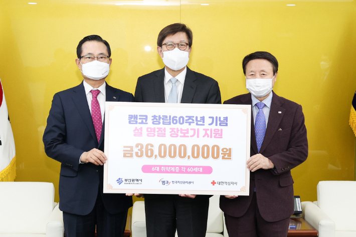 권남주 캠코 사장(왼쪽)이 24일 박형준 부산시장(중앙)에게 설 장보기 지원금 3천600만 원을 전달하고, 서정의 대한적십자사 부산지사회장과 함께 기념촬영을 하고 있다. 캠코 제공