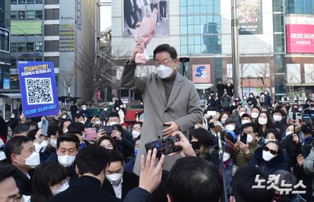 이재명 더불어민주당 대선후보가 26일 경기 고양시 덕양구 화정역 문화광장을 방문, 연설에 앞서 한 시민에게 받은 꽃다발을 들고 손인사를 하고 있다.