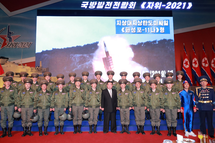 2021년 10월 국방발전전람회에 참석해 인민군을 독려하고 기념사진을 촬영한 김정은. 스크린에 '화성포-11나형'이라고 명명되어 있다. 뉴스1 제공