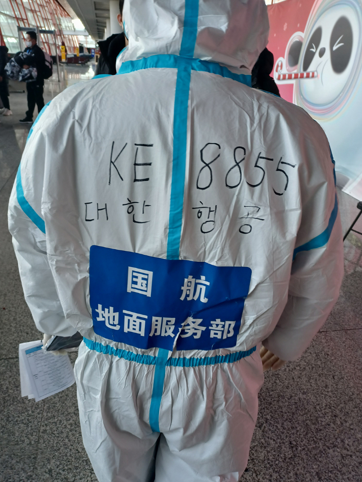 중국 베이징 서우두 공항 관계자가 도착한 한국 선수단이 동선을 헤메지 않게 한글로 '대한행공'과 편명을 적어 놓은 방호복을 입고 안내를 하고 있다. 노컷뉴스