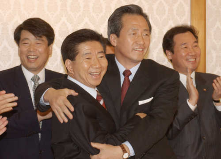 민주당 노무현. 국민통합 정몽준 대통령 당시 후보가 2002년 11월 저녁 국민여론조사에 의한 후보단일화에 합의한뒤 서로를 얼싸안고 있다. 연합뉴스