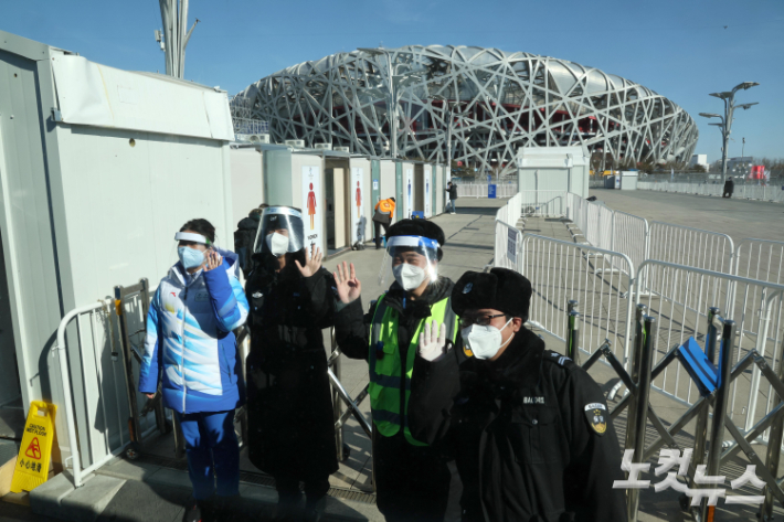 2022 베이징 동계올림픽 개막을 하루 앞둔 3일 중국 베이징 국립경기장 미디어출입구 앞에서 관계자들이 취재진을 향해 인사하고 있다. 베이징(중국)=박종민 기자