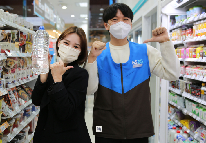 무라벨 생수를 들고 있는 모델과 업사이클 유니폼을 입은 모델이 포즈를 취하고 있다. GS25 제공 