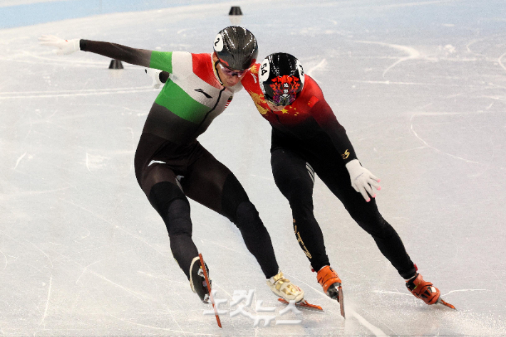 '이랬는데도 금이라니…' 중국 런쯔웨이(오른쪽)가 7일 중국 베이징 캐피털 인도어 스타디움에서 열린 쇼트트랙 남자 1,000m 결승전에서 결승선 직전 헝가리의 리우를 붙잡고 있다. 베이징(중국)=박종민 기자