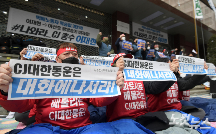 14일 오후 서울 중구 CJ대한통운 본사 앞에서 열린 전국택배노조 향후 투쟁계획 발표 기자회견에서 참석자들이 손 피켓을 들고 있다. 이한형 기자