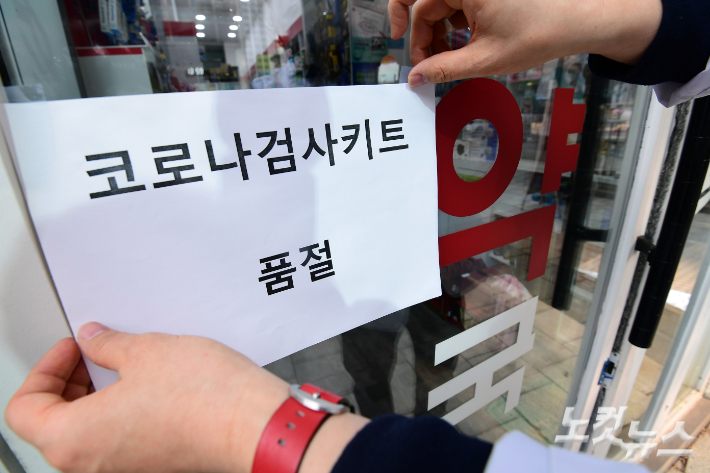 지난 11일 서울 중구 한 약국에서 약사가 '신속항원검사키트 품절' 안내문을 부착하고 있다. 황진환 기자