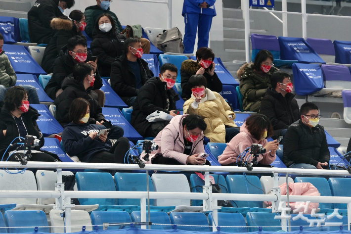 한일전이 열린 컬링 경기장에서 핸드폰을 바라보고 있는 관중들. 베이징=박종민 기자
