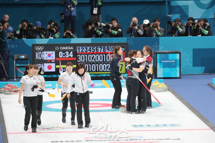 평창동계올림픽 당시 여자 컬링 4강전에서 한국 대표팀 선수들이 일본을 누른 뒤 얼싸안고 기뻐하는 모습. 일본 선수들이 씁쓸한 표정으로 경기장을 빠져나가는 모습이 대조를 이룬다. 이한형 기자