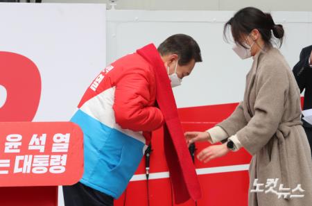 윤석열 국민의힘 대선 후보가 제20대 대통령 선거 공식 선거운동이 시작된 15일 오전 서울 중구 청계광장에서 열린 출정식에서 국회 인턴 이선아 씨에게 빨간목도리를 전달받고 있다.