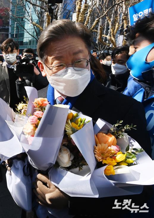 이재명 더불어민주당 대선 후보가 16일 서울 강남역에서 유세를 펼친 후 지지자로부터 꽃다발을 전달받고 있다.