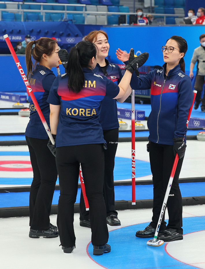 대한민국 여자 컬링 대표팀이 16일 중국 베이징 국립 아쿠아틱 센터에서 열린 2022 베이징 동계올림픽 여자 컬링 리그 한국과 덴마크의 경기에서 8-7로 역전승을 거둔 뒤 하이파이브를 하고 있다. 연합뉴스