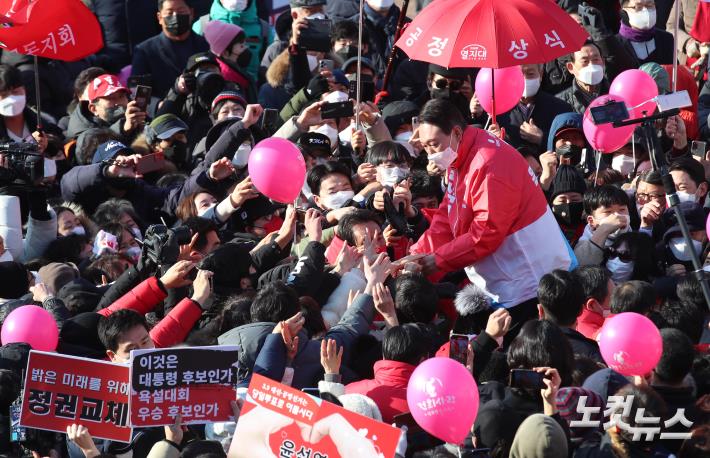 윤석열 국민의힘 대선후보가 17일 서울 서초구 서초동에서 유세를 마친 뒤 시민들과 손을 잡고 있다.