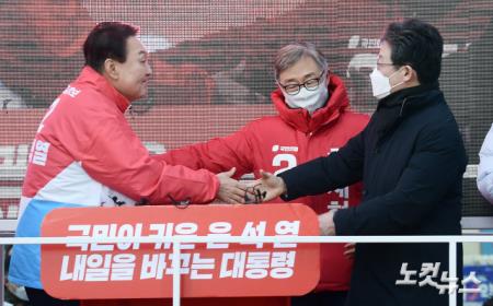 윤석열 국민의힘 대선 후보(왼쪽)가 17일 오후 서울 동묘앞역 일대에서 열린 "나라를 바로 세웁시다" 종로 지역 유세에서 윤 후보의 지원 유세를 위해 참석한 유승민 전 의원과 악수하고 있다.