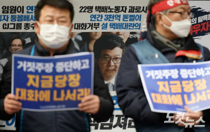 14일 오후 서울 중구 CJ대한통운 본사 앞에서 열린 전국택배노조 향후 투쟁계획 발표 기자회견에서 참석자들이 손 피켓을 들고 있다. 이한형 기자