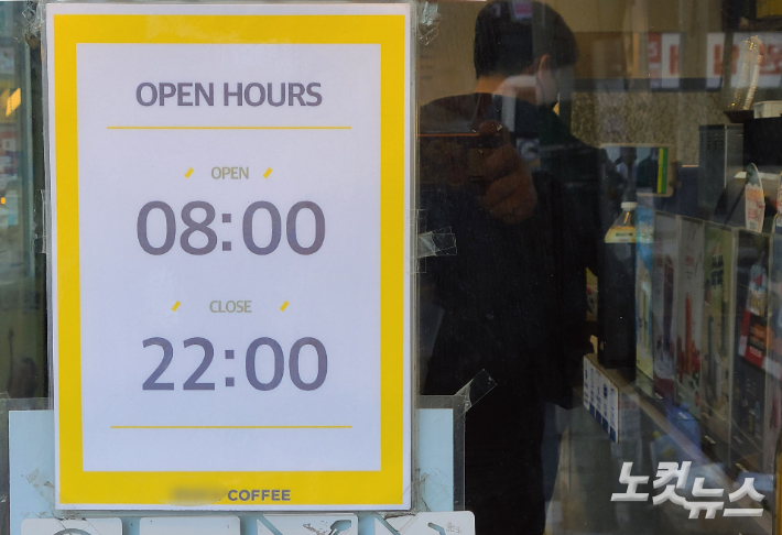 정부가 지난 19일부터 식당·카페 등의 영업시간 제한을 기존 밤 9시에서 10시로 한 시간 연장하고 인원은 그대로 6인으로 제한하기로 했다. 사진은 서울 시내의 한 커피숍에 영업시간이 붙어있는 모습. 이한형 기자