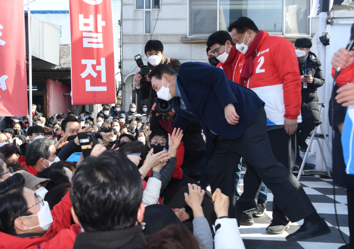 국민의힘 윤석열 대선 후보가 22일 충남 당진 시장중앙길 미소상가 앞에서 시민들과 악수 도중 중심을 잃고 있다. 윤창원 기자