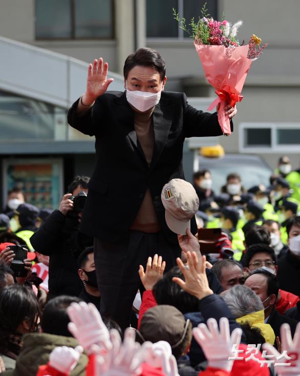 윤석열 국민의힘 대선 후보가 23일 오후 전남 목포시 호남동 목포역광장에서 열린 유세에서 꽃다발을 받아들고 있다.