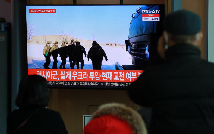 지난 22일 오전 서울역 대합실에서 시민들이 러시아·우크라이나 사태 뉴스 속보를 지켜보고 있다. 연합뉴스