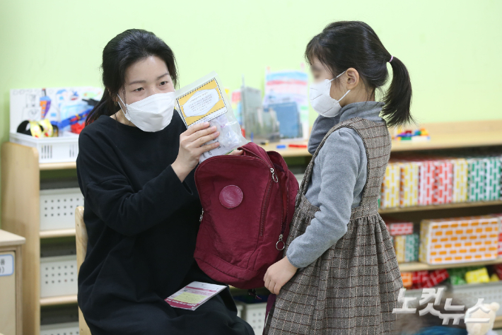 22일 오전 서울 구로구 서울항동유치원에서 한 교사가 어린이들에게 코로나19 자가진단키트를 배부하고 있다. 이한형 기자