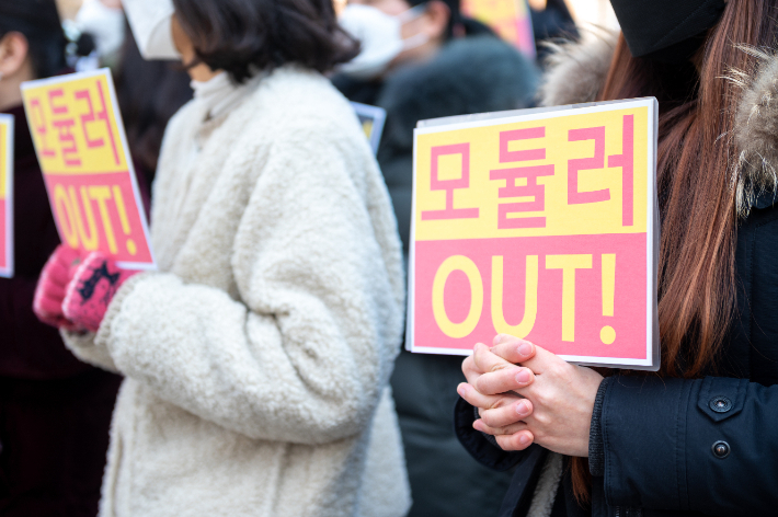 지난 24일 평택 서재초등학교 앞에서 학부모들이 모듈러 설치를 반대하는 손 피켓을 들고 있다.