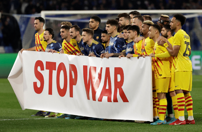 나폴리와 바르셀로나 선수들이 25일(한국 시각) 열린 2021-2022 UEFA 유로파리그 16강 플레이오프 2차전에 앞서 '전쟁 반대' 문구가 적인 현수막을 들어보이고 있다. 연합뉴스