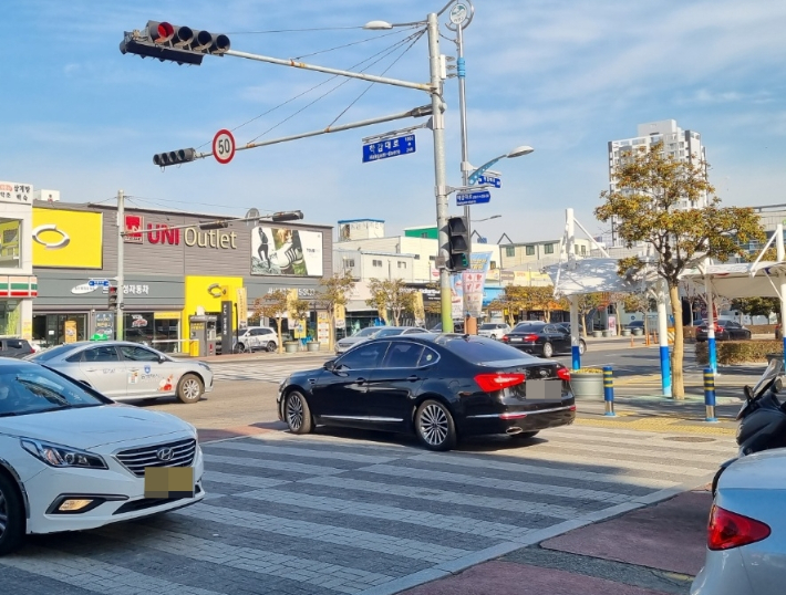 28일 부산의 한 교차로 횡단보도에서 차량 신호 적색, 보행자 신호 녹색일 때 한 차량(가운데)이 우회전하고 있다. 박진홍 기자
