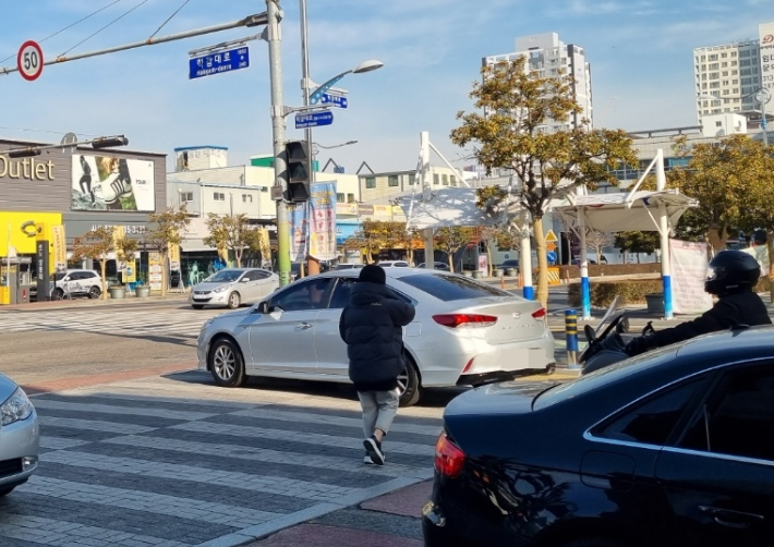 28일 부산의 한 교차로 횡단보도에서 녹색 신호에 길을 건너는 보행자 앞으로 한 차량이 우회전하고 있다. 박진홍 기자