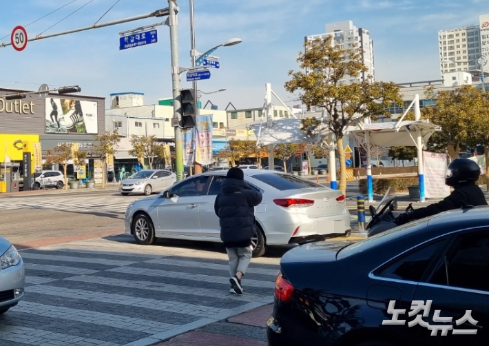 28일 부산의 한 교차로 횡단보도에서 녹색 신호에 길을 건너는 보행자 앞으로 한 차량이 우회전하고 있다. 박진홍 기자