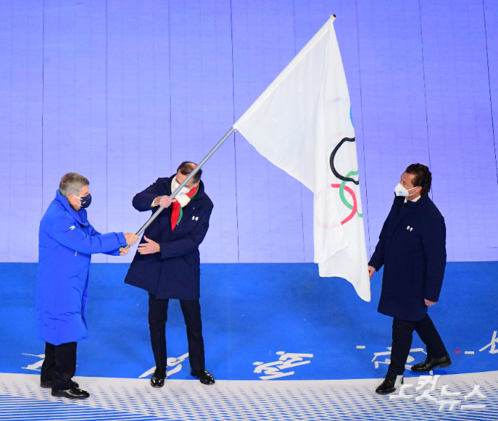 20일 오후 중국 베이징 국립경기장에서 열린 2022 베이징동계올림픽 폐막식에서 토마스바흐 IOC위원장이 2026년 동계올림픽 차기 개최지인 밀라노 시장과 코르티나담페초 시장에게 올림픽기를 이양하고 있다. 베이징(중국)=박종민 기자