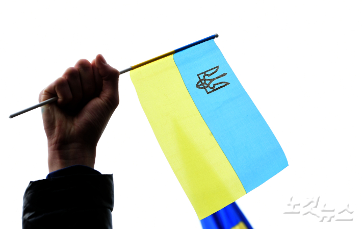 28일 오전 서울 중구 주한 러시아 대사관 앞에서 열린 '러시아의 우크라이나 침공 중단·평화적 해결 촉구 시민사회 공동 기자회견'에 참석한 재한 우크라이나인이 국기를 흔들고 있다. 황진환 기자