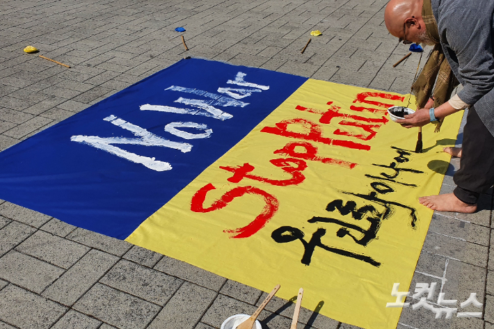 2일 전북 전주시 풍남문 앞에서 열린 반전문화제. 행위 예술가 심홍재씨가 우크라이나의 평화를 기원하는 메시지를 담은 행위 예술을 하고 있다. 송승민 기자