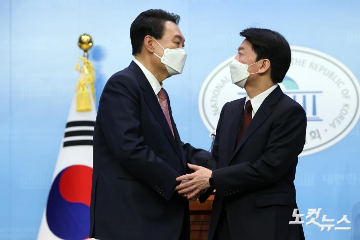 윤석열 국민의힘 대선 후보와 안철수 국민의당 대선 후보가 3일 오전 서울 여의도 국회 소통관에서 단일화 기자회견을 마치고 악수하고 있다.