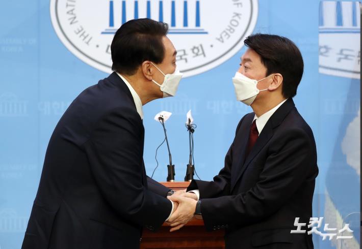 야권 단일화에 전격 합의한 국민의힘 윤석열 대선 후보와 국민의당 안철수 대선 후보가 3일 오전 서울 여의도 국회 소통관에서 공동 기자회견을 마친 뒤 함게 손을 잡고 있다.