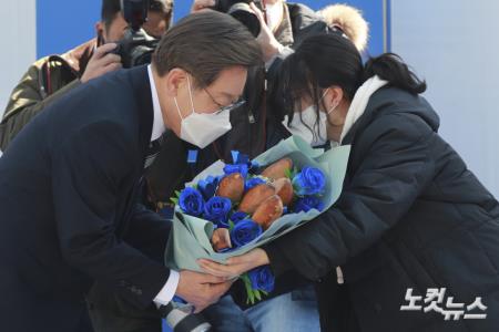 이재명 더불어민주당 대선후보가 3일 오후 서울 종로 보신각터에서 열린 '우리 모두를 위해, 성평등 사회로' 유세에서 세계 여성의 날을 의미하는 빵과 장미를 받고 있다.