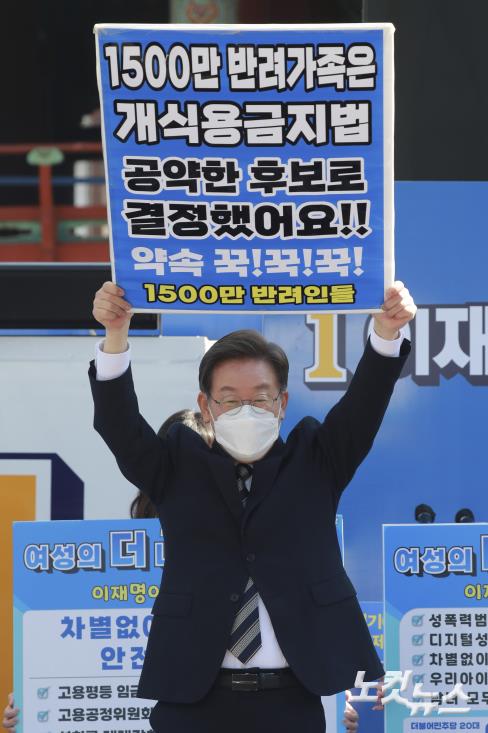 이재명 더불어민주당 대선후보가 3일 오후 서울 종로 보신각터에서 열린 '우리 모두를 위해, 성평등 사회로' 유세에서 지지자에게 전달받은 개식용금지법 관련 피켓을 들고 있다.