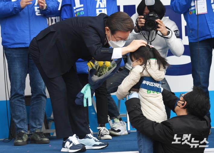 이재명 더불어민주당 대선 후보가 3일 서울 강서구 발산역 유세에서 꽃다발을 건넨 아이의 머리를 쓰다듬고 있다.