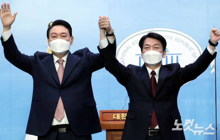 윤석열 국민의힘 대선 후보와 안철수 국민의당 대선 후보가 3일 오전 서울 여의도 국회 소통관에서 단일화 기자회견을 마치고 손을 맞잡고 있다. 윤창원 기자