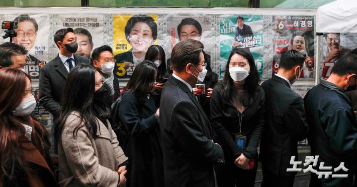 제20대 대통령선거 사전투표가 시작된 4일 서울 중구 소공동주민센터에 마련된 투표소에서 이재명 더불어민주당 대선후보가 투표를 하기 위해 줄을서며 시민들과 대화하고 있다.